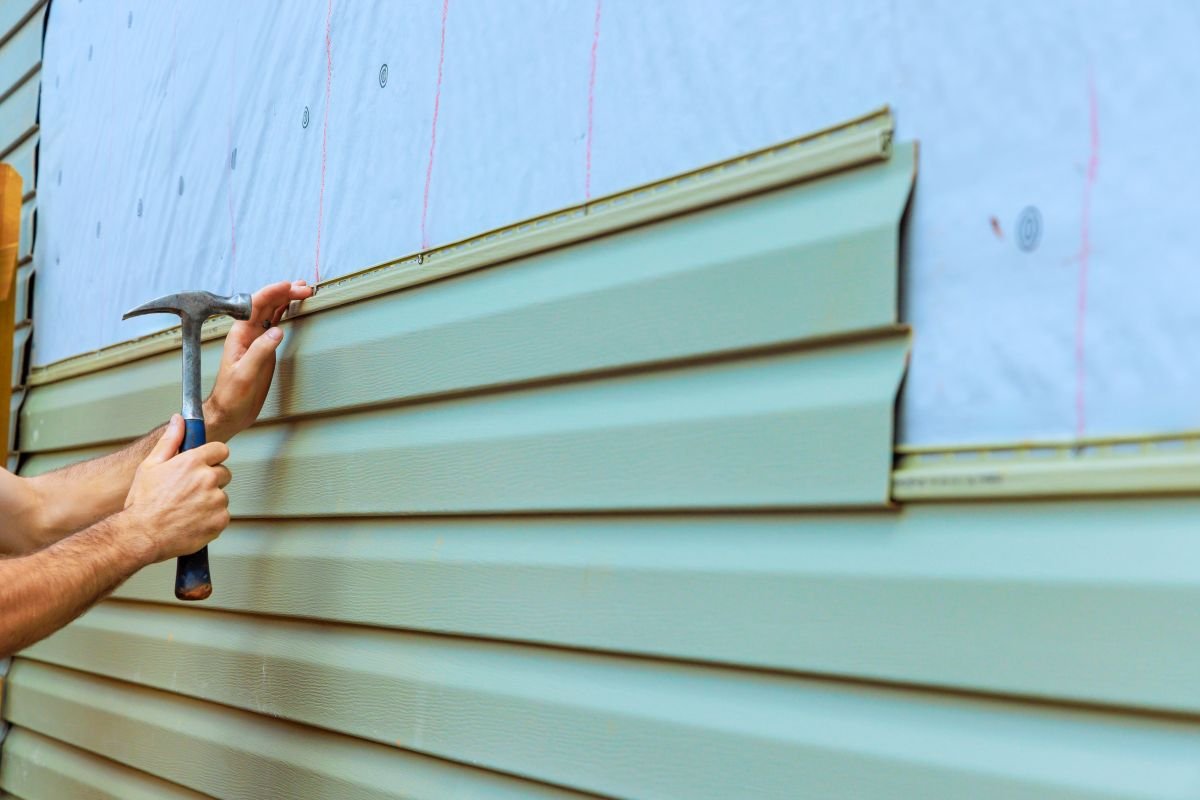 Home improvement project involves installing new siding on an exterior wall with a focus on detail and craftsmanship